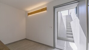 A modern interior with a staircase leading to a balcony.
