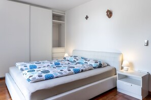 A bedroom with a bed, nightstand, and wardrobe.