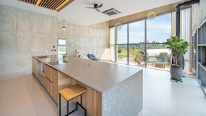 Een moderne keuken met een groot eiland, een inbouwoven en uitzicht op de stad.