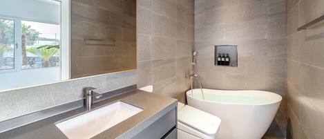 Une salle de bain moderne avec une grande baignoire, un lavabo et une douche.