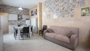 A compact living space with a kitchenette, dining area, and a sofa.