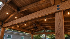 Una terraza de madera con un jacuzzi, luces colgantes y un ventilador de techo.
