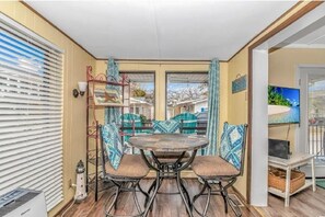Enjoy a peaceful stay in this serene room with a round table and two chairs near a window, perfect for relaxation.