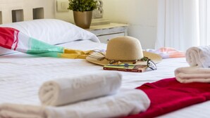 A neatly made bed with a white pillow, a red and green towel, a straw hat, and a book on the bed. - 231 Parque Santiago II, 2 bedrooms, 2 bathrooms, Wi-Fi, beach and pool (Arona)