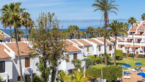 A resort with white buildings, palm trees, and a view of the sea. - 231 Parque Santiago II, 2 bedrooms, 2 bathrooms, Wi-Fi, beach and pool (Arona)