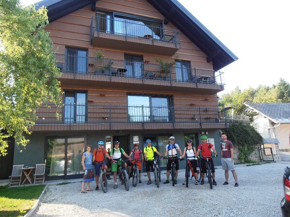 A multi-story building with balconies, a gravel driveway, and a tree. - Base Camp: Cozy retreat in a mountain village (Križe)