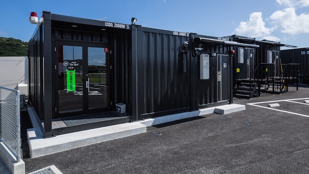 A modern building with a black exterior, a glass entrance, and a sign indicating "The Yard". - HOTEL R9 The Yard Uruma (Uruma)