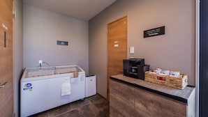 A hotel room with a minibar, a coffee machine, and a basket of snacks. - HOTEL R9 The Yard Uruma (Uruma)