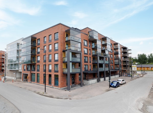 A multi-story residential building with a modern architectural design, featuring balconies and large windows. - Hiisi Homes Hämeenlinna Asemanranta (Hameenlinna)