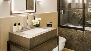 Ein modernes Badezimmer mit einem großen Waschbecken, einer Toilette und einer Duschkabine.