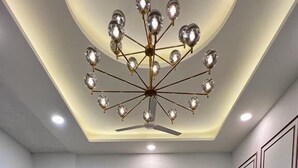A modern living room with a central coffee table, sofas, and a unique chandelier. - The Dream House (New Delhi)