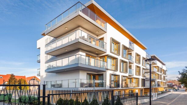 Un immeuble résidentiel à plusieurs étages, doté de balcons, de grandes fenêtres et d’une architecture moderne.
