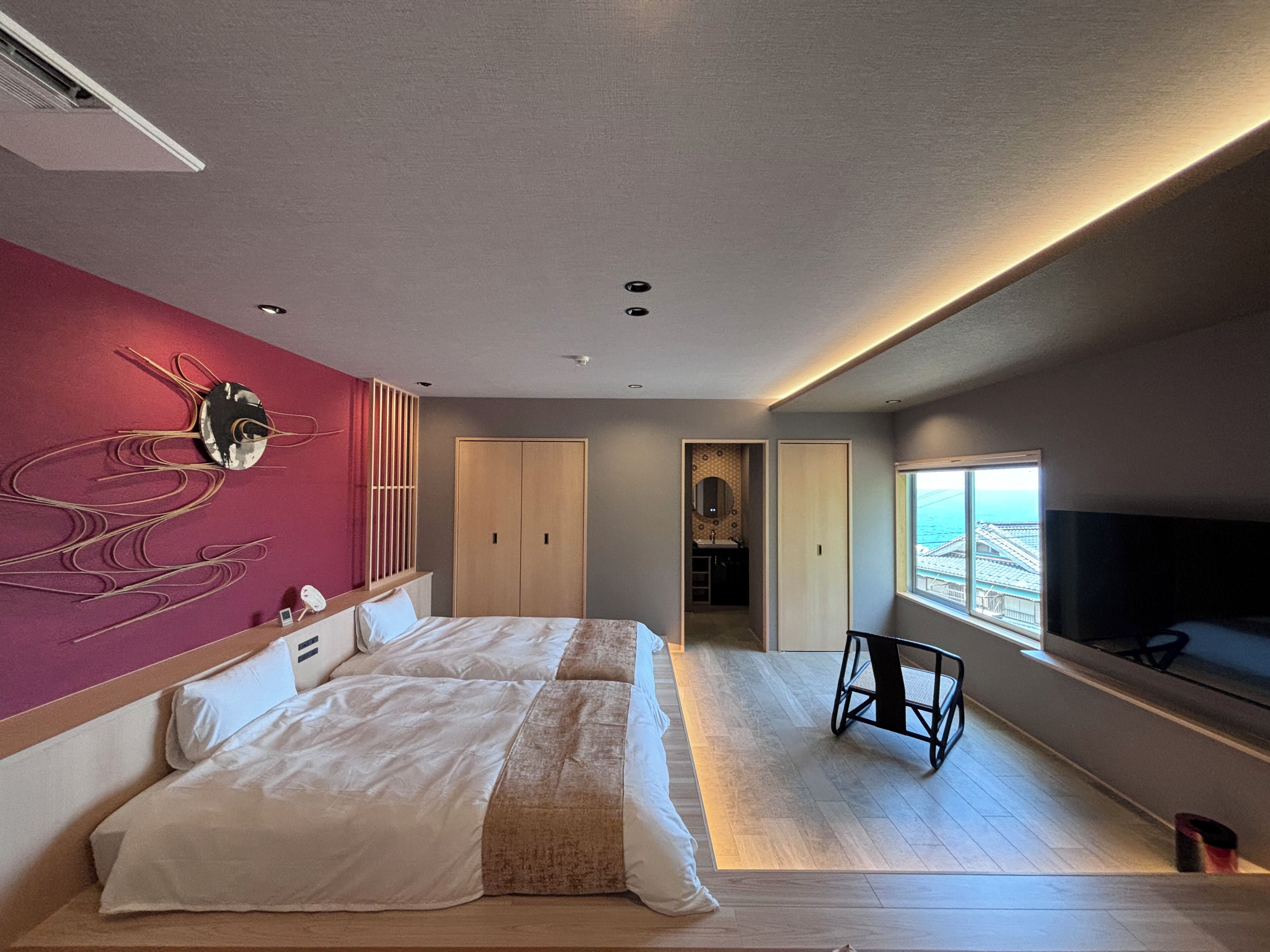 Een moderne hotelkamer met een groot bed, een televisie en uitzicht op de stad.