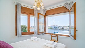 Een hotelkamer met een bed, een stoel en uitzicht op een stadsbeeld en water.