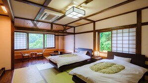 Une pièce de style japonais traditionnel, avec un sol recouvert de tatamis, deux lits dotés de literie verte, un plafond en bois et de grandes fenêtres offrant une vue sur la verdure.