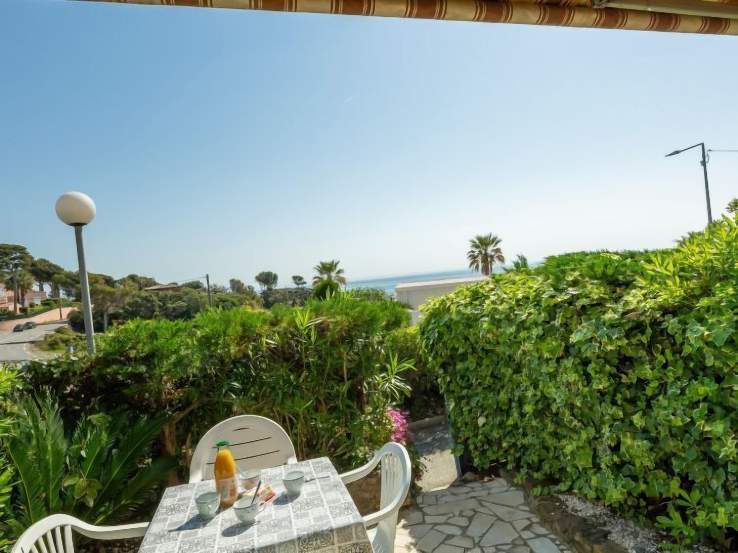 A patio with a table set for two, overlooking a coastal view.