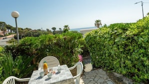 Un patio con una mesa lista para dos, con vista al mar.