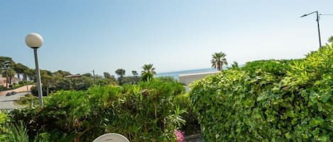 A patio with a table set for two, overlooking a coastal view.