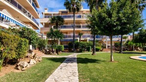 A multi-story hotel with a stone pathway leading to a pool area, surrounded by well-maintained lawns and palm trees. - Los Aticos by Interhome (Dénia)