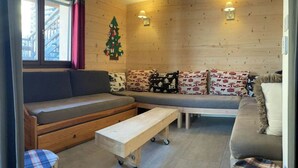 A cozy living room with a sofa, a wooden bench, and a small table. - No. 2, capacity: 14 people (Vars)