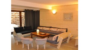 A cozy living room with a sofa, two armchairs, a coffee table, and a lamp. - No. 6, maximum 14 people (Vars)
