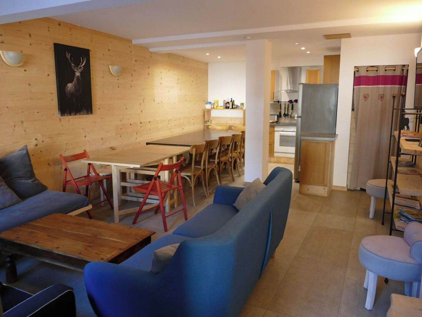 Un salon moderne avec un canapé, une table basse en bois et un coin repas avec des chaises.