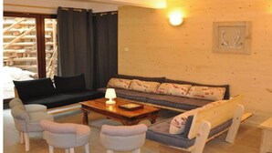 Una sala de estar acogedora con un sofá, dos sillones, una mesita de centro y una lámpara.