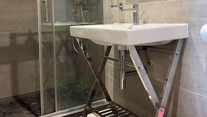 A modern bathroom with a glass shower enclosure, a white sink, and a mirror. - No. 7, maximum 7 people (Vars)