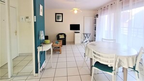 A compact living space with a dining area, a television, and a small seating area.