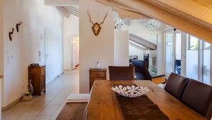 A dining area with a wooden table, chairs, and a chandelier.