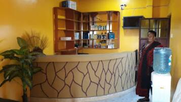 A reception area with a curved counter, a water dispenser, and a bookshelf.