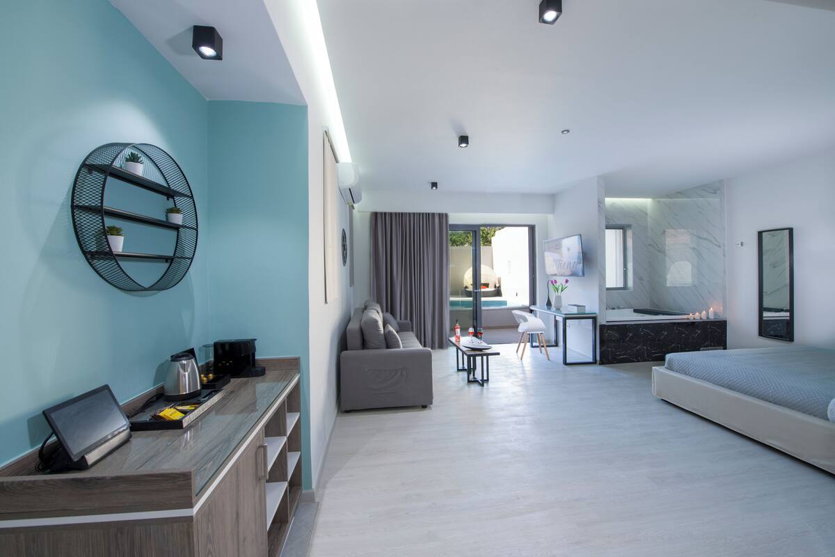 Una habitación de hotel moderna con sala de estar, comedor y dormitorio.