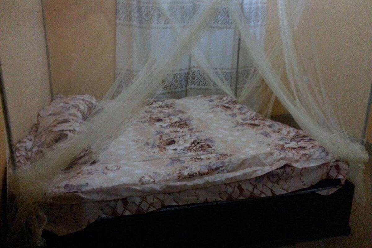 A bed with a floral bedspread and a white canopy.