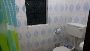 A small bathroom with a toilet, a window, and a toilet paper holder. - Tala Village Inn (Tala)