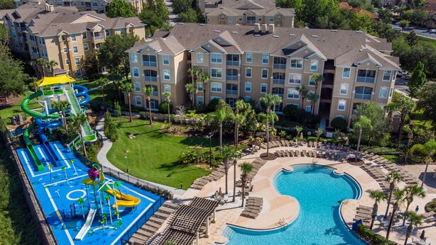 A resort with a large pool, a water park, and multiple apartment buildings.