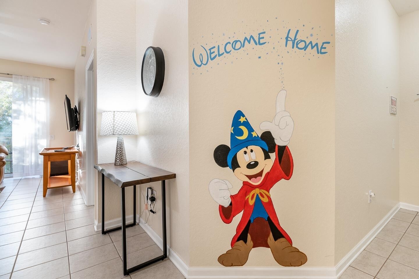 Une pièce dont un mur est décoré d’une fresque représentant un personnage de dessin animé, une horloge et un panneau d’accueil.