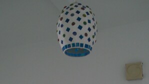 Ein Zimmer mit einer weißen Tür, einem Lichtschalter und einer Deckenleuchte.