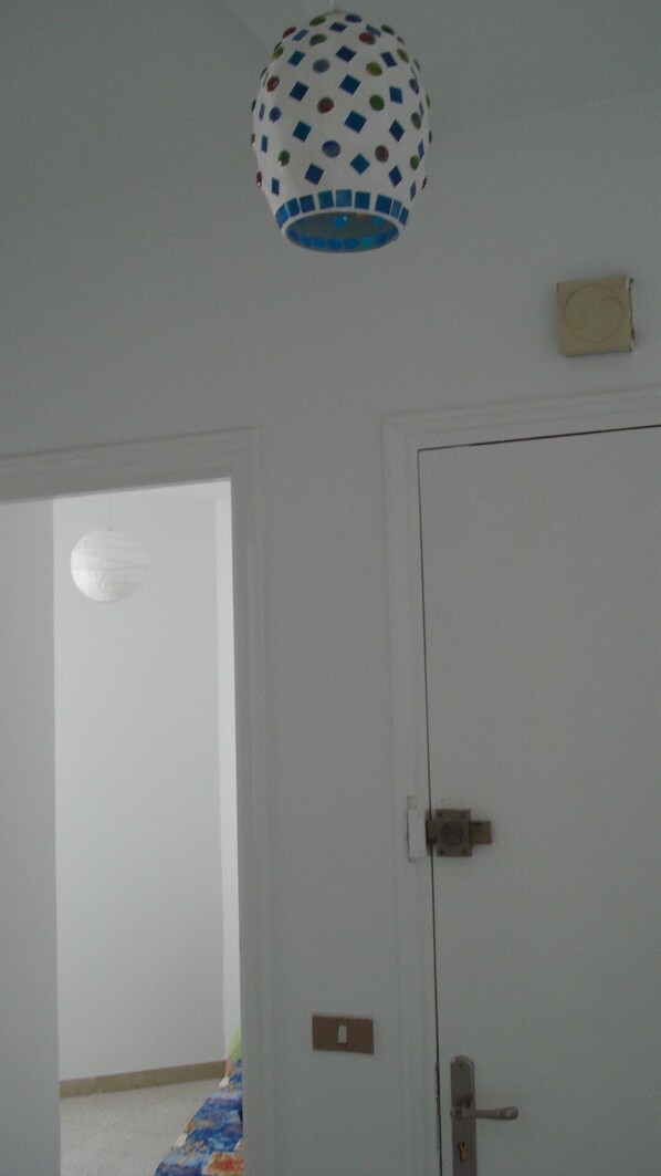 A room with a white door, a light switch, and a ceiling light fixture. - Exceptional location in downtown Tunis; available for year-round rental. (Tunis)
