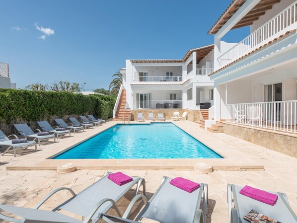 A poolside area with lounge chairs and a swimming pool. - New Apartment DOR, Pool, Wifi, Ac, Bbq, Cala Dor (Cala D'or (Santanyí))