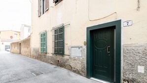 A building with a green door, a number '7' sign, and a street with a 'STOP' sign in the background. - GuestHost - Bright and functional 35 sqm apartment, able to accommodate up to 2 people, located on the first floor (without elevator) of a building within Gioberti district. The property is located in a lively neighborhood, full of services and well serv (Firenze)