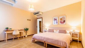 A bedroom with a bed, bedside tables, a desk, a chair, and a potted plant. - Agriturismo Il Bio Nonno - Alloggio Bombo (San Matteo della Decima)