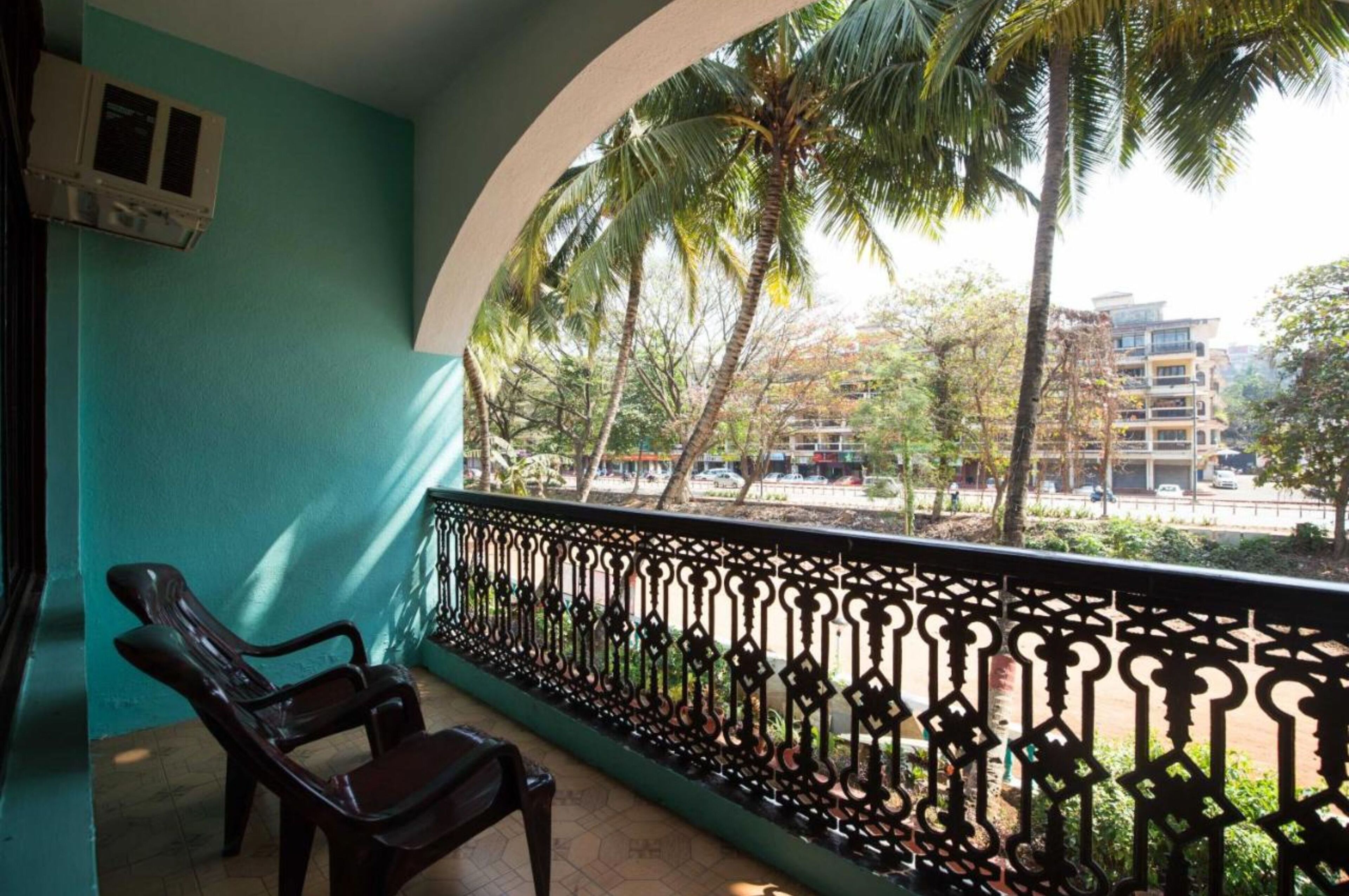 A balcony with a view of palm trees and buildings.