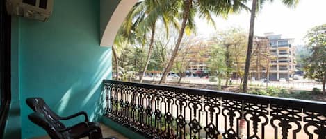 Un balcón con vistas a palmeras y edificios.