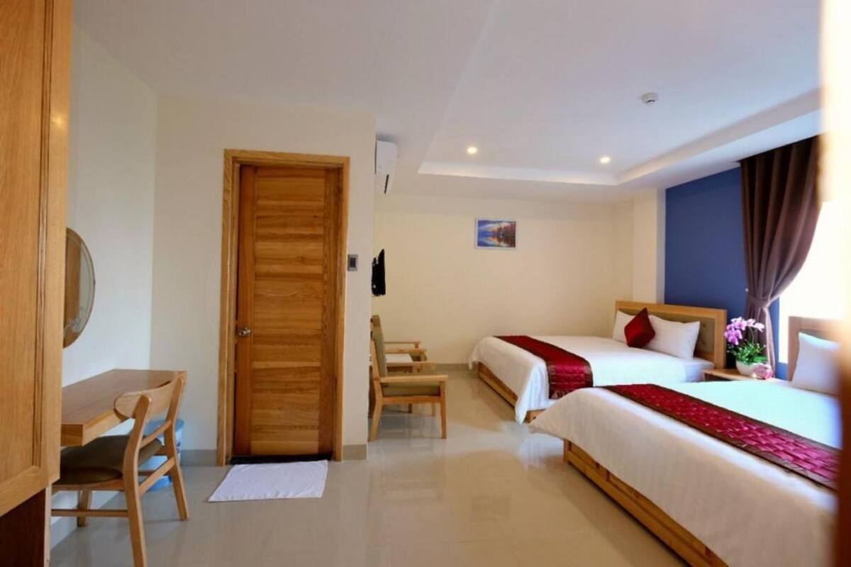 Una habitación de hotel con dos camas, un escritorio y una silla.