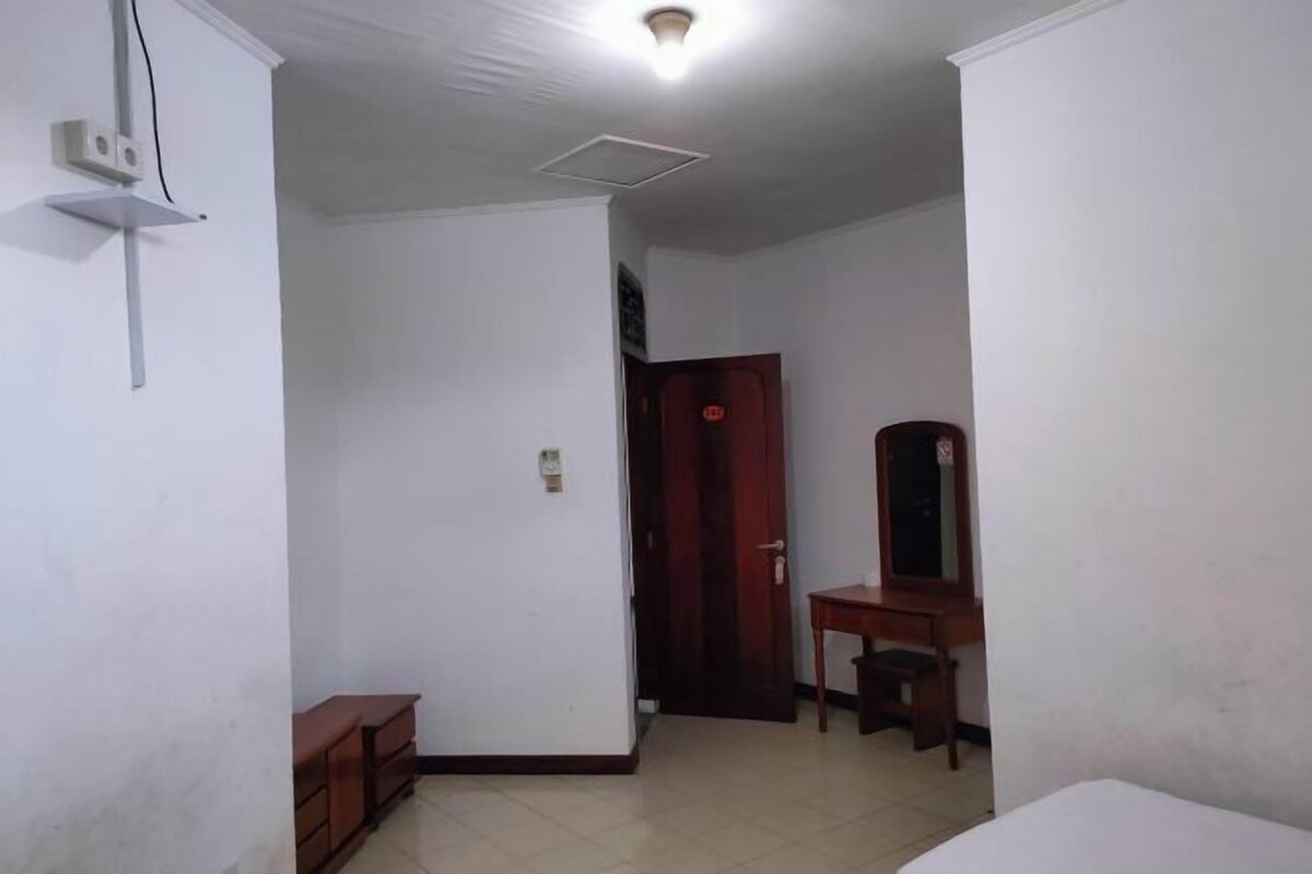 A room with a bed, a desk, a chair, and a wardrobe.