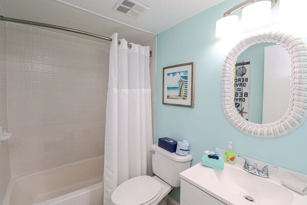 A bathroom with a shower, toilet, sink, and a mirror. - St Augustine Beach & Tennis Club Condos 306-Beautiful Ocean Views! (St. Augustine)