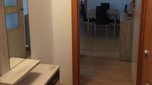 Un pasillo con una puerta de madera que da a un comedor.