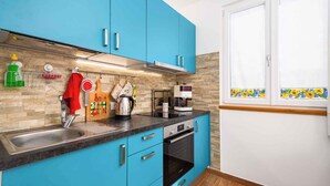 A kitchen with blue cabinets, a stainless steel sink, and a built-in oven. - Holiday apartment with internet and air conditioning near the sea (Umag)