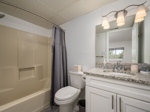 Une salle de bain avec une baignoire, des toilettes et un meuble-lavabo avec un miroir.