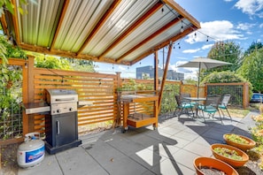 Enjoy al fresco dining and cooking with a barbecue grill, compact refrigerator, and dining area.
